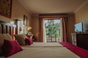 um quarto de hotel com uma cama com uma grande janela em Hotel Spa Villalba em Vilaflor