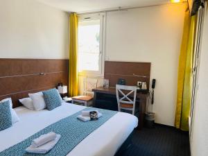 - une chambre avec un lit, un bureau et une fenêtre dans l'établissement Hotel & Spa Gil de France Cap d'Agde, au Cap d'Agde