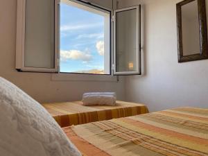 ロザスにあるAquariumのベッド2台、景色を望む窓が備わる客室です。
