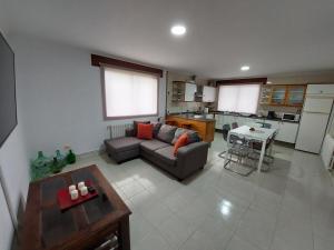- un salon avec un canapé et une table dans l'établissement Acogedora Casa de campo- BAJO con finca-, à Neda