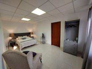 a bedroom with a bed and a dresser in it at Acogedora Casa de campo- BAJO con finca- in Neda