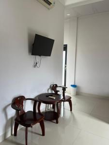 Ấp Khánh Phước (1)的住宿－KHACH SAN HOAN VU，一间设有两把椅子、一张桌子和一台电视的房间