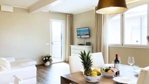 ein Wohnzimmer mit einem Tisch und einer Obstschale in der Unterkunft Falconetta Luxury House in Portoferraio