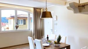 ein Esszimmer mit einem Tisch und einem Fenster in der Unterkunft Falconetta Luxury House in Portoferraio