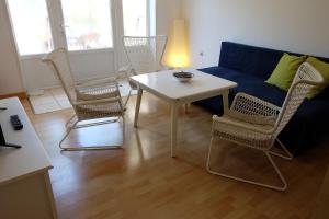 sala de estar con sofá azul, sillas y mesa en Apartments Golubic en Pula