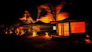 un bâtiment avec des lumières devant lui la nuit dans l'établissement Captains Desert Camp, à Wadi Rum