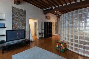 a living room with a tv and a wall with glass at Fillungo180 in Lucca