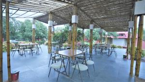un grupo de mesas y sillas en un pabellón en Amraness Luxury Resort Sasan Gir, en Sasan Gir
