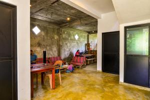 une salle avec des tables et des chaises et des personnes assises à des tables dans l'établissement 2b1 weligama, à Weligama