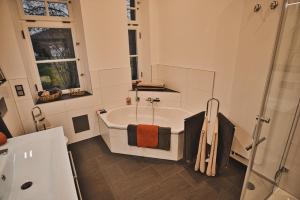 biała łazienka z wanną i prysznicem w obiekcie Feriendomizil Villa Neidstein w mieście Neukirchen bei Sulzbach-Rosenberg