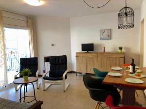 a living room with a table and chairs and a television at Apartamentos Aquarium in Roses