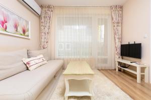 a living room with a white couch and a table at Bright & Cozy 1BD Flat with a Terrace and Parking in Plovdiv