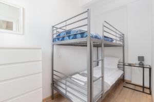 metalowe łóżko piętrowe w pokoju z białymi ścianami w obiekcie Apartment Beachy Dream by Renters w Gdańsku