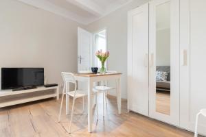 Biały pokój ze stołem, krzesłami i telewizorem w obiekcie Apartment Beachy Dream by Renters w Gdańsku