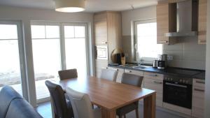 a kitchen with a wooden dining table and chairs at Ostseeperle in Kappeln