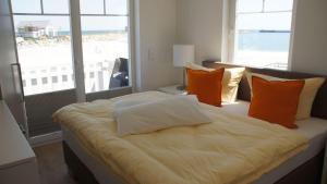 a bedroom with a bed with orange and white pillows at Ostseeperle in Kappeln