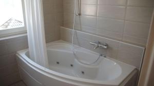 a bathroom with a bath tub with a shower at Ostseeperle in Kappeln +13 photos