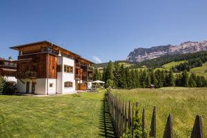 a house in the mountains with a fence at Appartamenti Les Viles in La Villa
