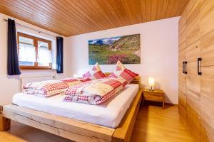 Un dormitorio con una cama con almohadas. en Chiemgauferienwohnungen - Wanderlust und Alpenrose en Unterwössen