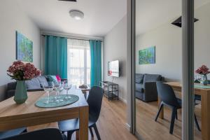 a living room and dining room with a table and chairs at Okecie Airport Studio Bakalarska 2 P&O Serviced Apartments in Warsaw