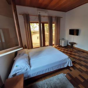 a bedroom with a bed and a large window at Ocean View Guesthouse in São Tomé