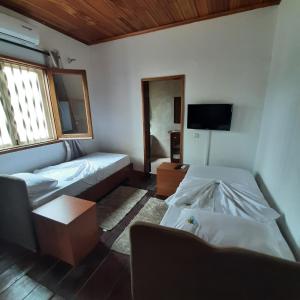 a room with two beds and a tv in it at Ocean View Guesthouse in São Tomé