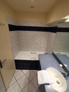 a bathroom with a toilet and a sink and a tub at Hotel Des Falaises in Étretat