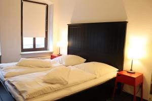 two beds in a room with two lamps and a window at alexxanders Apartments & Studios in Chemnitz