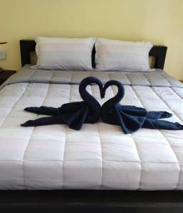 Dos cisnes formando un corazón en una cama en Sunanta Bungalow en Ko Lanta