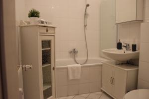 alexxanders Apartments & Studios في شيمنيتز: حمام مع حوض وحوض استحمام ومرحاض