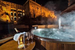 uma banheira de hidromassagem com taças de vinho e uma garrafa de champanhe em Mill Apartments em Cesky Krumlov