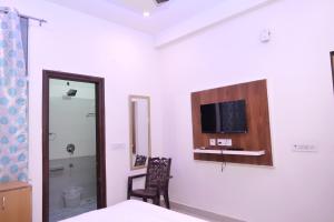 a room with a bed and a tv on the wall at HOTEL IRA Mansarovar Jaipur in Jaipur +7 photos