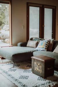 sala de estar con sofá y mesa en Three Little Pigs Escape - MAIN HOUSE ONLY en South Bruny
