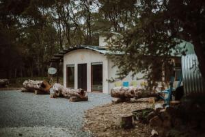 a group of logs sitting in front of a building at Three Little Pigs Escape - MAIN HOUSE ONLY in South Bruny