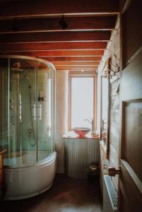 a bathroom with a tub and a shower with a window at Three Little Pigs Escape - MAIN HOUSE ONLY in South Bruny