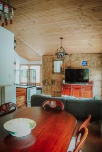 sala de estar con mesa de madera y sofá en Three Little Pigs Escape - MAIN HOUSE ONLY en South Bruny