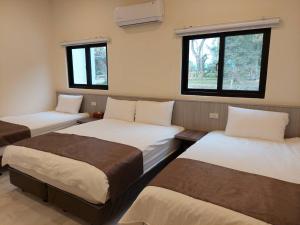 a room with three beds and two windows at Meinong Yun Shanju Homestay in Meinong