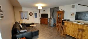 salon z kanapą i telewizorem w obiekcie La talonnière, maison de village avec terrasse et 3 chambres w mieście Messas +15 zdjęć