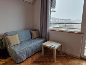 una pequeña sala de estar con sofá y mesa. en Malavi A5 top center apartment Ruse en Ruse