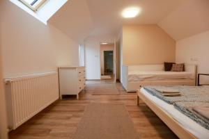 a bedroom with two beds and a skylight at Amande House & Cottage in Vonyarcvashegy