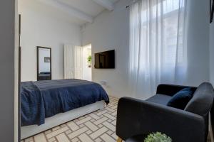 a bedroom with a bed and a couch and a television at Idyllic Apartment close to Valletta in Il-Furjana