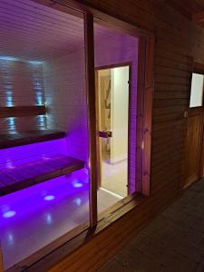 an empty room with purple lights on a door at Amande House & Cottage in Vonyarcvashegy