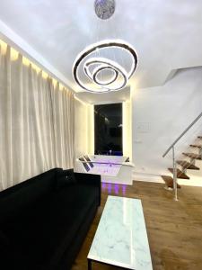 a living room with a black couch and a chandelier at Apartament z jacuzzi in Krakow +8 photos