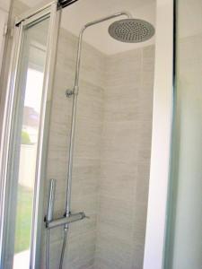 a shower with a glass door in a bathroom at Asteria in Ouistreham