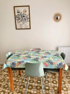 a dining room table with a colorful table cloth on it at Asteria in Ouistreham