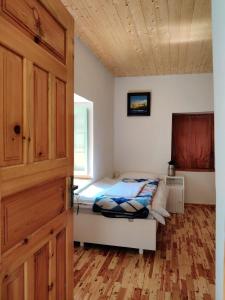 - une chambre avec un lit et un plafond en bois dans l'établissement Gemoor Khar- Manor House, à Jispa