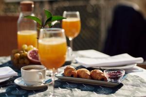 a table with a plate of food and glasses of orange juice at Hotel Lovran in Lovran