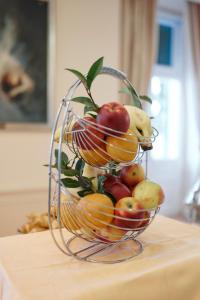 a wire basket filled with fruit on top of a table at Hotel Lovran in Lovran
