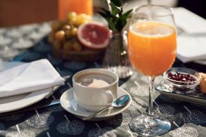 a table with a cup of coffee and a glass of orange juice at Hotel Lovran in Lovran