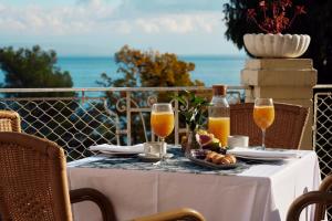 a table with glasses of orange juice and a plate of food at Hotel Lovran in Lovran